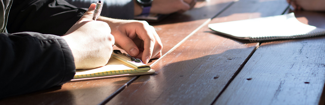 A person taking notes in a meeting.