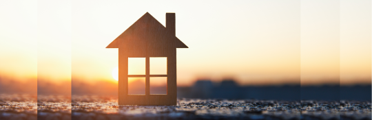 Cutout of a house silhouetted against a sunset