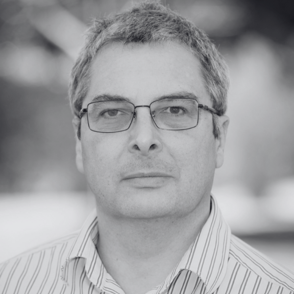 Headshot of Kip Werren, a man with short hair and glasses, wearing a striped shirt