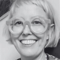 Headshot of Sarah Marland, a woman with short, blond hair wearing thick-rimmed glasses and smiling