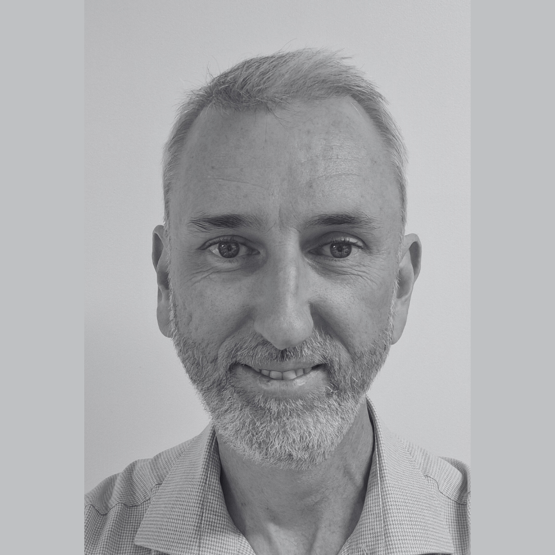 Headshot of Patrick O'Callahan smiling slightly. He has short hair and is wearing a button-up shirt.