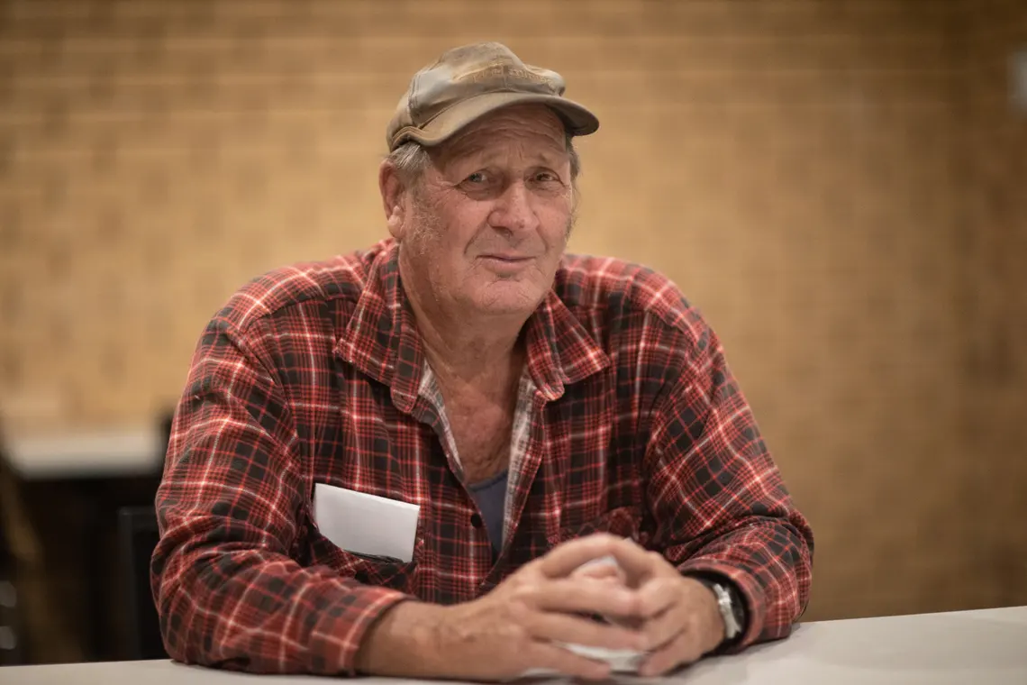 Portrait of a man wearing a flannel shirt and a hat. 