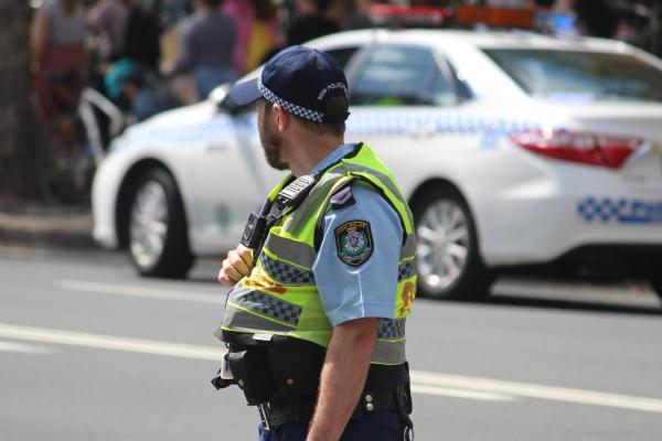 A NSW Police officer wearing a high-vis yellow vest.