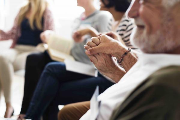 People holding hands in a community support group.