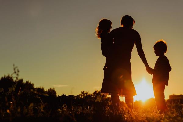 Silhouette of woman and two kids