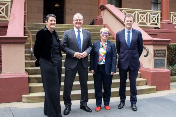 Four people standing outside NSW Parliament House: Katrina Ironside (Executive Director, Community Legal Centres NSW), Michael Daley (Shadow Attorney General), Sarah Marland (Policy and Advocacy Manager, Community Legal Centres NSW), and The Hon. Mark Speakman (Attorney General).