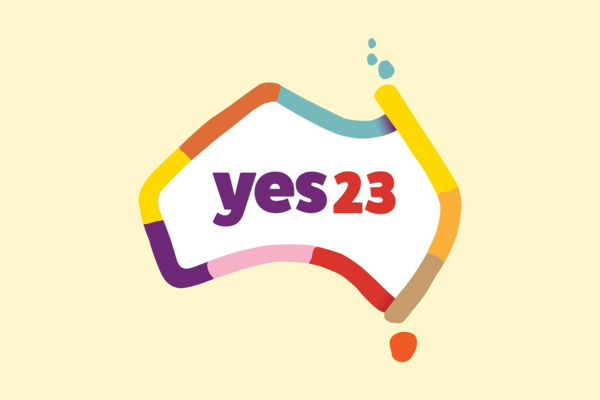 Yes 23 campaign logo with a light yellow background and a colourful outline of so-called Australia with text reading 'Yes 23' in the middle