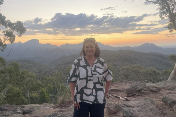 RRR Intern Bethany Sherry smiling in front of a sunset in Coonabarabran